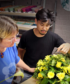 Jacqueline Boerma teaching a student how to make a Drop-Shape Funeral Arrangement