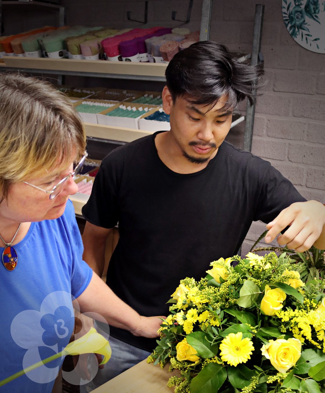 Jacqueline Boerma teaching a student how to make a Drop-Shape Funeral Arrangement